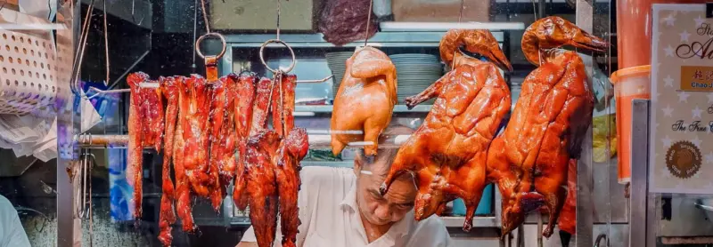 Vibrant market stall with assorted roasted meats, showcasing culinary street food delicacies.